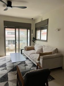 a living room with a couch and a table at The Urban Retreat by IsrApart in Ra‘ananna