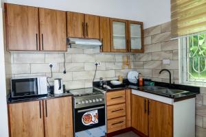 a kitchen with a stove top oven next to a microwave at VanVei Villas and Apartments in Dar es Salaam