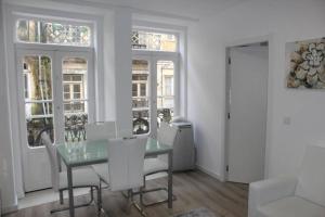 a dining room with a glass table and white chairs at Sunday Lovers - FB - 96 in Coimbra +21 photos