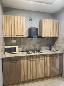 a kitchen with a stove and a microwave at Résidence AMIRAL in Niamey