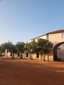 a large white building with trees in front of it at Résidence AMIRAL in Niamey