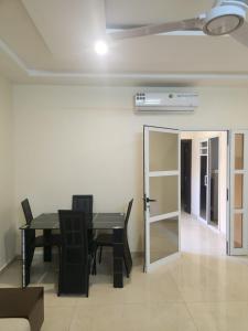 a dining room with a table and chairs and a door at Résidence AMIRAL in Niamey +10 photos