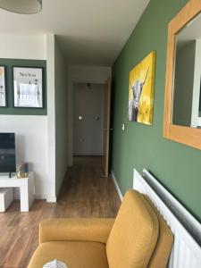 a living room with green walls and a chair at Modern 1-Bedroom Apartment in The Hub, Milton Keynes - FREE PARKING in Milton Keynes