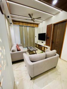 a living room with two couches and a tv at Meralya Woods - In the Luxe of Nature in Solan