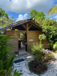 een houten schuur met een houten pergola bij Caraiba - Maisons de Vacance avec Piscine et Toit Terrasse in Sainte-Anne