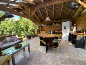 een keuken en een woonkamer met een houten plafond bij Caraiba - Maisons de Vacance avec Piscine et Toit Terrasse in Sainte-Anne