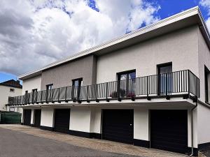 a white building with a balcony on top of it at Neues Ruhrtal Apartment 2 in Wickede (Ruhr)