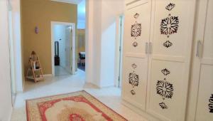 a living room with a white wall with black stencils at villa mimosa avec parking intérieur in Tataouine