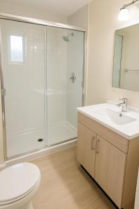 a bathroom with a shower and a toilet and a sink at Thoiry Étoile Lodge in Thoiry