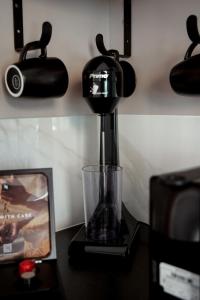 Una cafetera negra sobre una mesa con un televisor. en Tropical Beach "Orion", en Petalidi