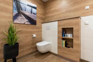 a bathroom with a toilet and a plant in it at Ferienhaus SUNSET am Mühlfeldsee in Löbnitz