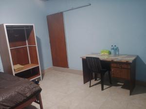 a room with a desk and a table with chairs at Wel home stay in Pulau Gilimota +12 photos
