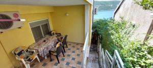 a table and chairs on the balcony of a house at Apartmani Jelena in Neum