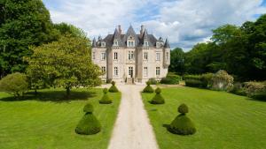 an estate with a row of trees in the grass at Château de la Grange Moreau in Vallon-sur-Gée