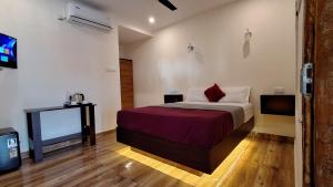 a bedroom with a bed and a tv in it at Bella Casa Beach Resort in Varkala