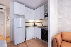 a small kitchen with white cabinets and a refrigerator at Loft Old Town - Unik Vacation in Tarragona