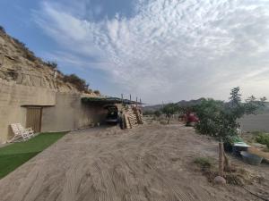 a building with a dirt road next to the water at Cueva Rural con Encanto in Cuevas del Almanzora +9 photos