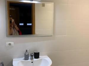 Eine Frau, die ein Bild von einem Waschbecken im Bad macht. in der Unterkunft Attenery in Las Palmas de Gran Canaria + 8 Fotos