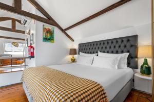 a bedroom with a large bed with a checkered blanket at Quinta Colina by Shiadu in Lisbon