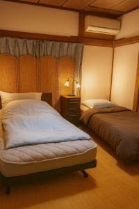 ein Schlafzimmer mit 2 Betten und einer Lampe in der Unterkunft One Room in Pusang Gala in Yuki