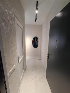 a hallway with a door to a room with a tile floor at Gelati Loft Apartment in Kutaisi +8 photos
