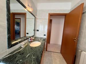 a bathroom with a sink and a large mirror at Appartamento Gemma D'oro in Castellammare del Golfo +12 photos