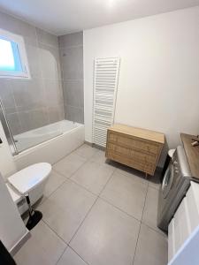 a bathroom with a toilet and a tub and a sink at Paris Studio Cosy luxe avec jardin Proche métro in Romainville +39 photos