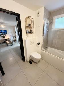 a bathroom with a toilet and a walk in shower at Paris Studio Cosy luxe avec jardin Proche métro in Romainville