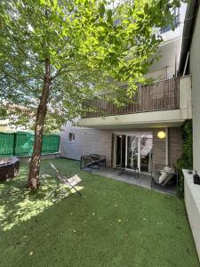 a yard with a tree and a building at Paris Studio Cosy luxe avec jardin Proche métro in Romainville