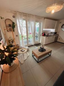 a living room with a table and a kitchen at Paris Studio Cosy luxe avec jardin Proche métro in Romainville