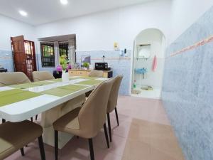 a dining room with a long table and chairs at Bukit Beruang 366D Family Home - Private Pool in Melaka