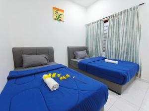 two beds with blue sheets in a room at Bukit Beruang 366D Family Home - Private Pool in Melaka +57 photos