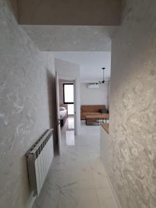 a room with a hallway with a bed and a living room at Gelati Loft Apartment in Kutaisi