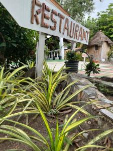 a sign for a resort with plants in front of it at African Treasure Gardens And surf Resort in Kokrobite
