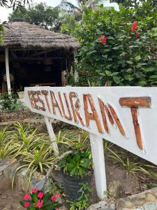 a sign that says sikkim in front of a house at African Treasure Gardens And surf Resort in Kokrobite