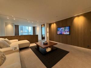 首尔Maison 9 - Hongdae的客厅里有一张白色的沙发和一张桌子