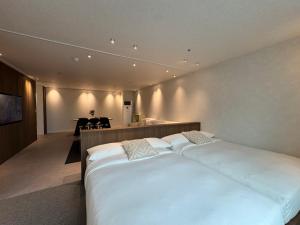 a bedroom with a large white bed and a dining room at Maison 9 - Hongdae in Seoul +19 photos