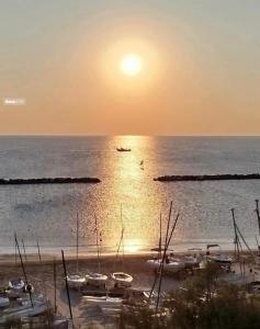 a group of boats in the water at sunset at Apartment Sunrise Pesaro in Pesaro +5 photos