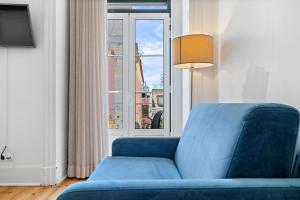 a blue couch in a room with a window at Quinta Colina by Shiadu in Lisbon