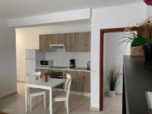 a kitchen with a white table and chairs in a room at Ferienwohnung Luna in Charco del Palo