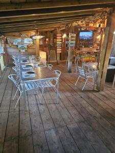 a dining room with tables and chairs on a wooden floor at Camping familial les Chalets d'Uza in Uza