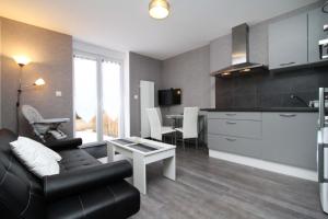 kuchnia i salon z kanapą i stołem w obiekcie Gite-les-myrtilles w mieście Corcieux +4 zdjęcia