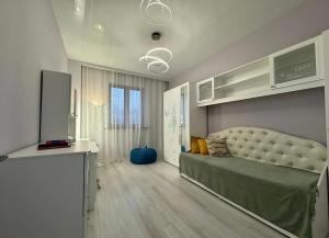 un salon avec un lit et une cuisine dans l'établissement Guest House, à Almaty