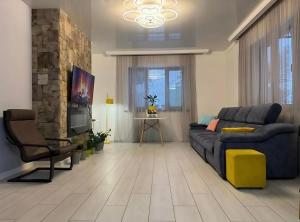 un salon avec un canapé bleu et une télévision dans l'établissement Guest House, à Almaty