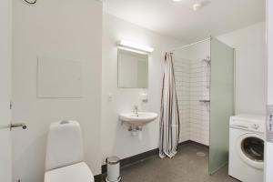 a white bathroom with a sink and a washing machine at Teaterhotellet in Horsens +57 photos
