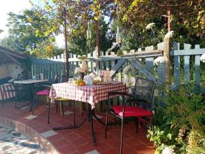 a table and chairs on a patio with a fence at Camping Voi-la-la-vie in Saint-Christophe-en-Boucherie