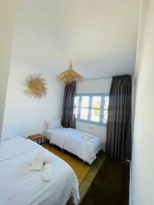 a room with two beds and a window at Appartement Coucher de Soleil uniquement les familles in Oualidia