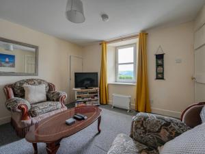 sala de estar con mesa de centro y TV en Holiday Home The Manor House by Interhome, en Balnain