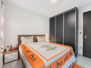 a bedroom with a bed with an orange and white blanket at Holiday Home Luxury Retreat Resort by Interhome 