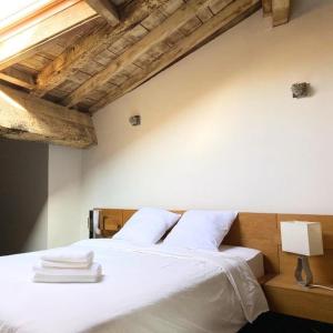 a bedroom with a white bed with towels on it at La table ronde in Vienne